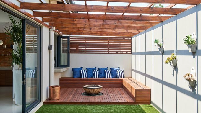 A pergola with benches and a fire pit in its center