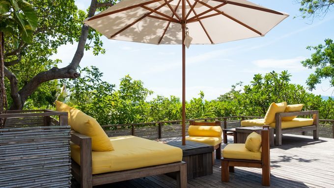 A backyard sitting area with shade provided by a white umbrella.