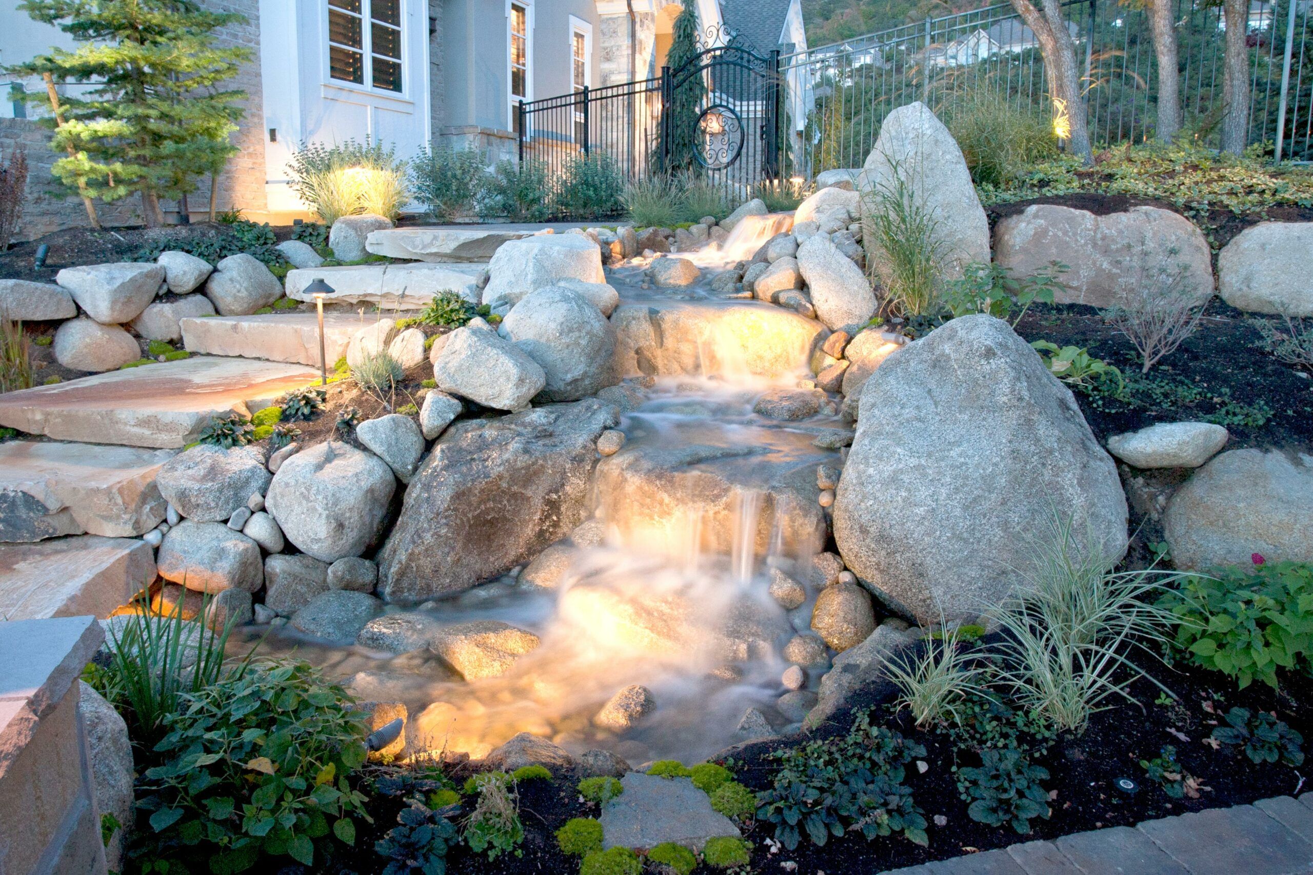 A large rock water feature in a garden.