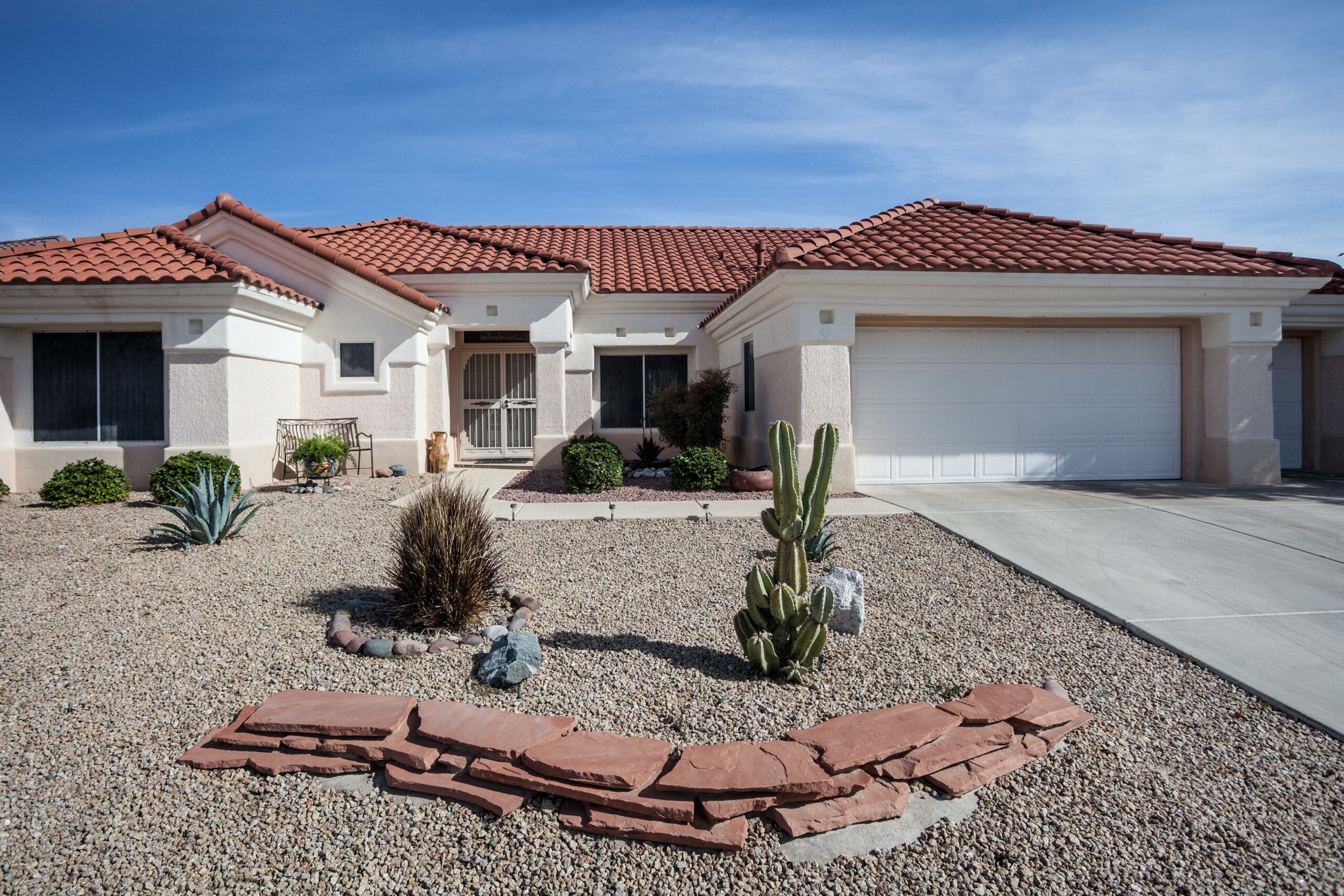 A house with a rock garden and succulents landscaping it's front yard.