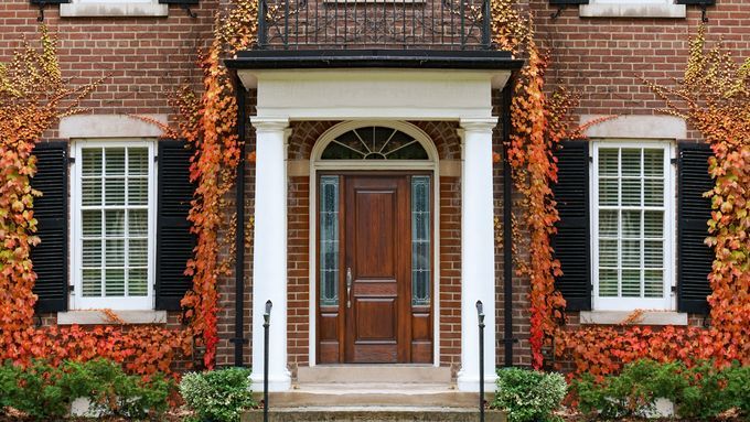 The front of a brick home on a Fall day.