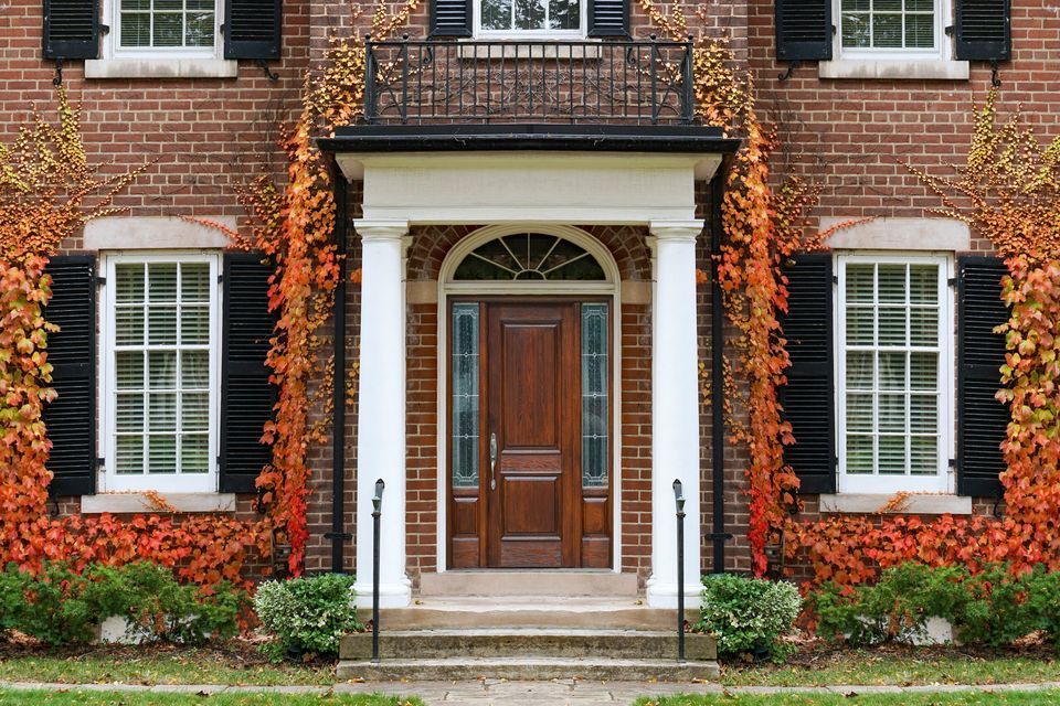 The front of a brick home on a Fall day.