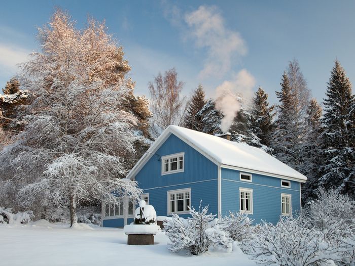 A house covered in snow with a chimney and chimney flue.