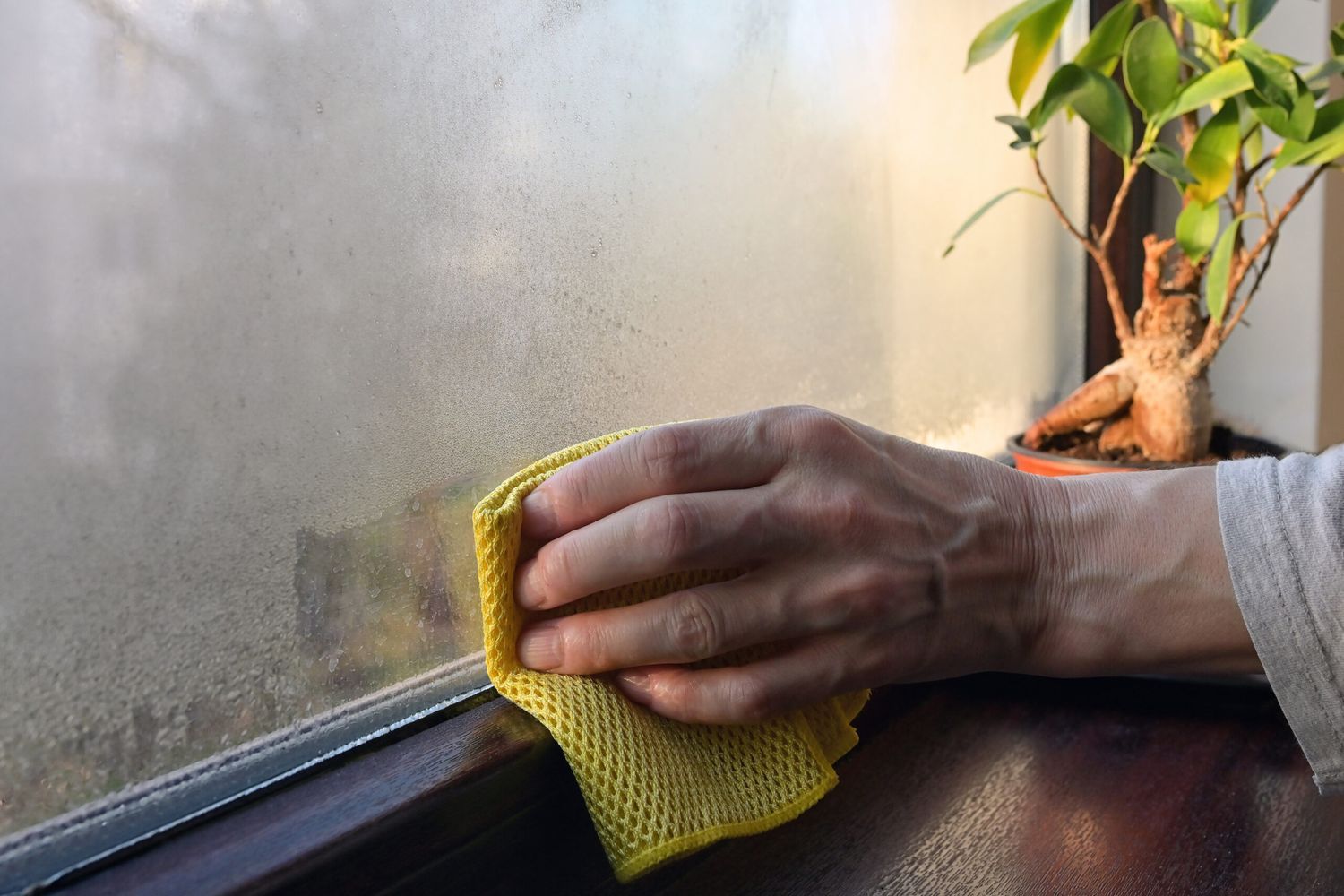 Cloth wiping away condensation on a window.