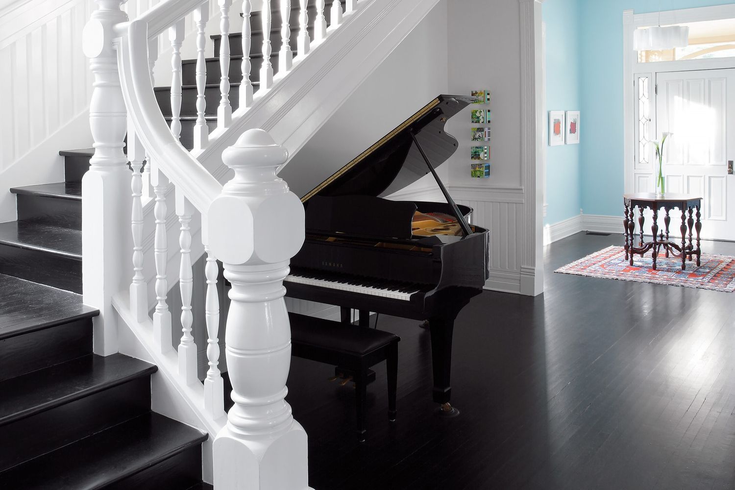 A grand staircase with elaborate details and a grand piano.
