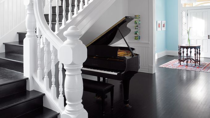 A grand staircase with elaborate details and a grand piano.