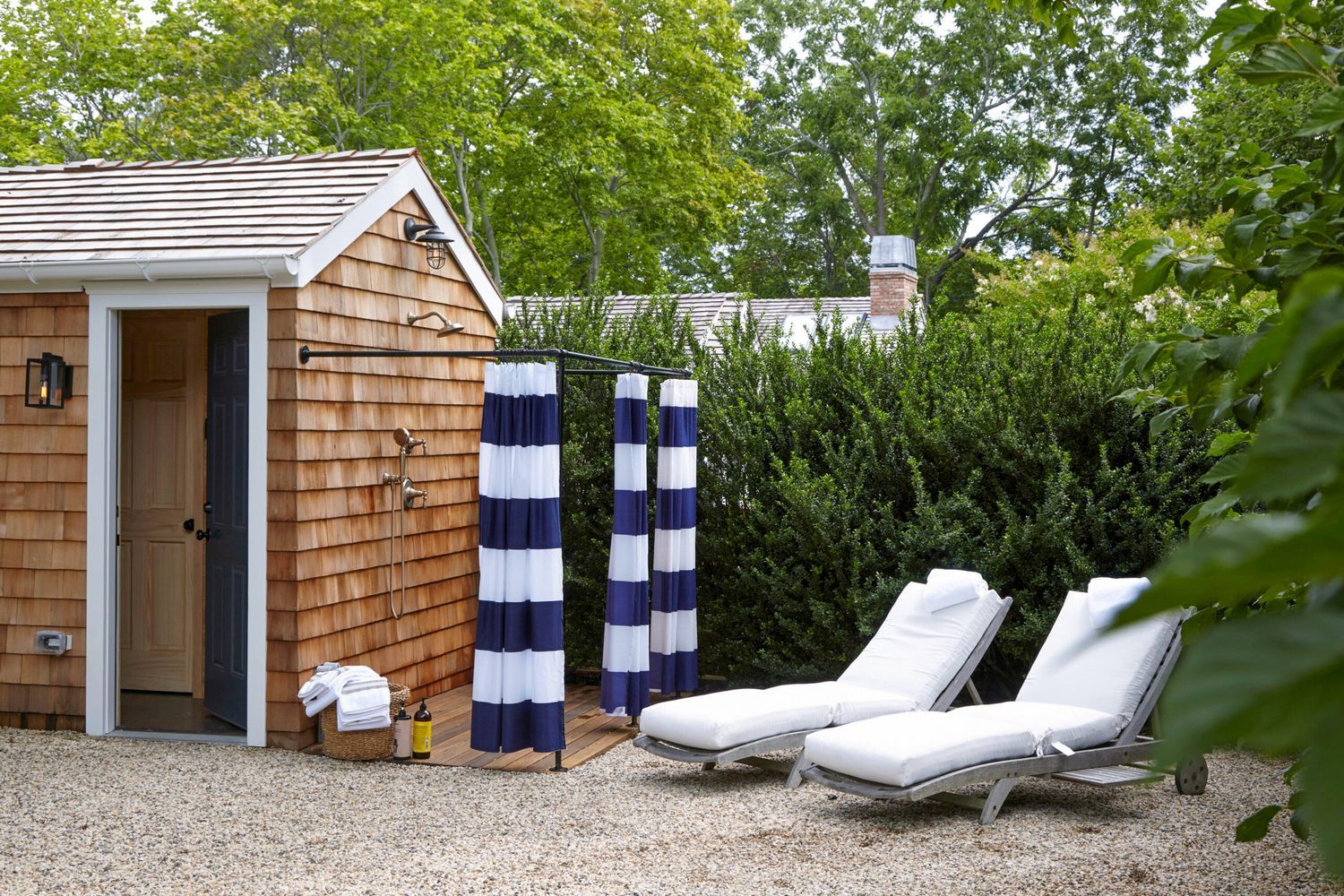 Outdoor shower attached to the side of a building in a yard.