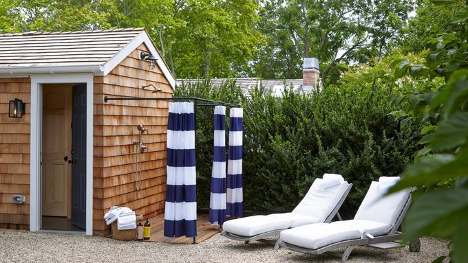 Outdoor shower attached to the side of a building in a yard.