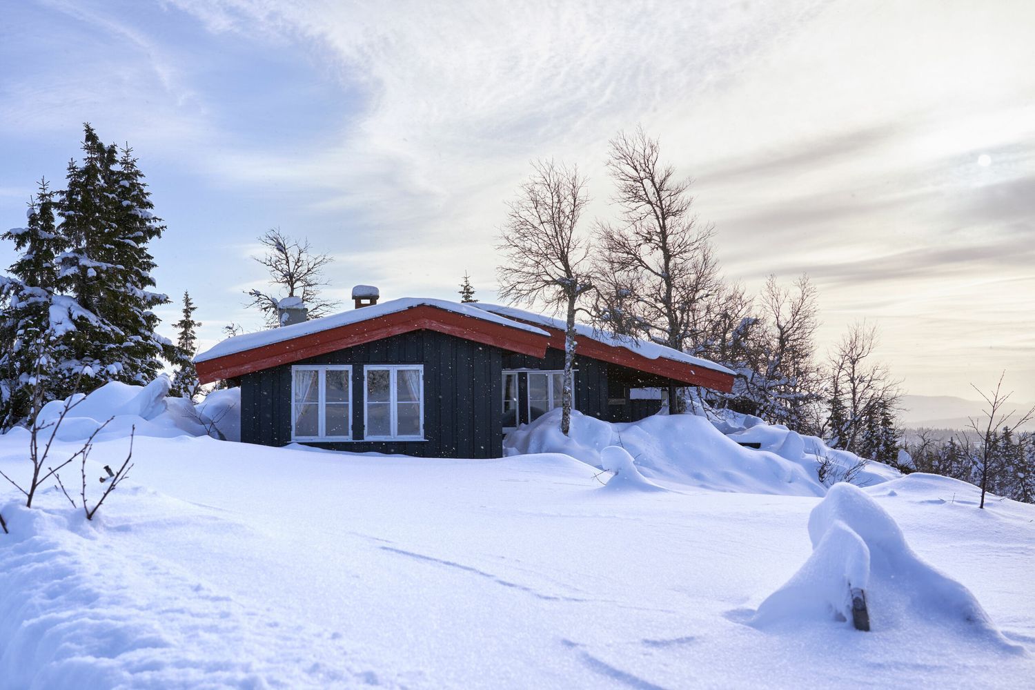 A snowed in cabin in the winter.