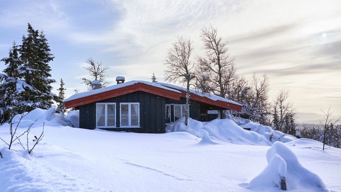 A snowed in cabin in the winter.