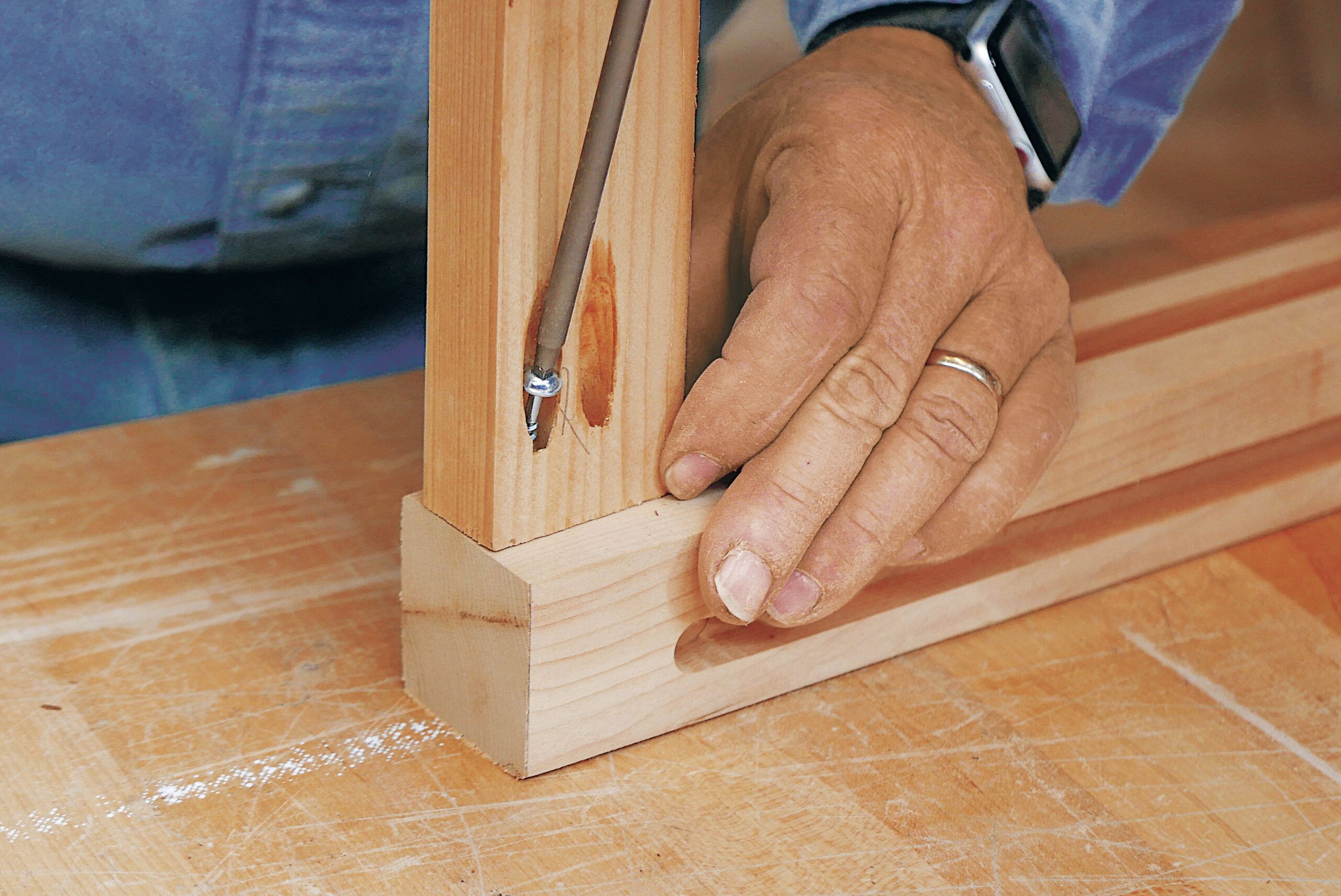 Tom Silva using a pocket-hole jig to drill pocket holes in each rail. 