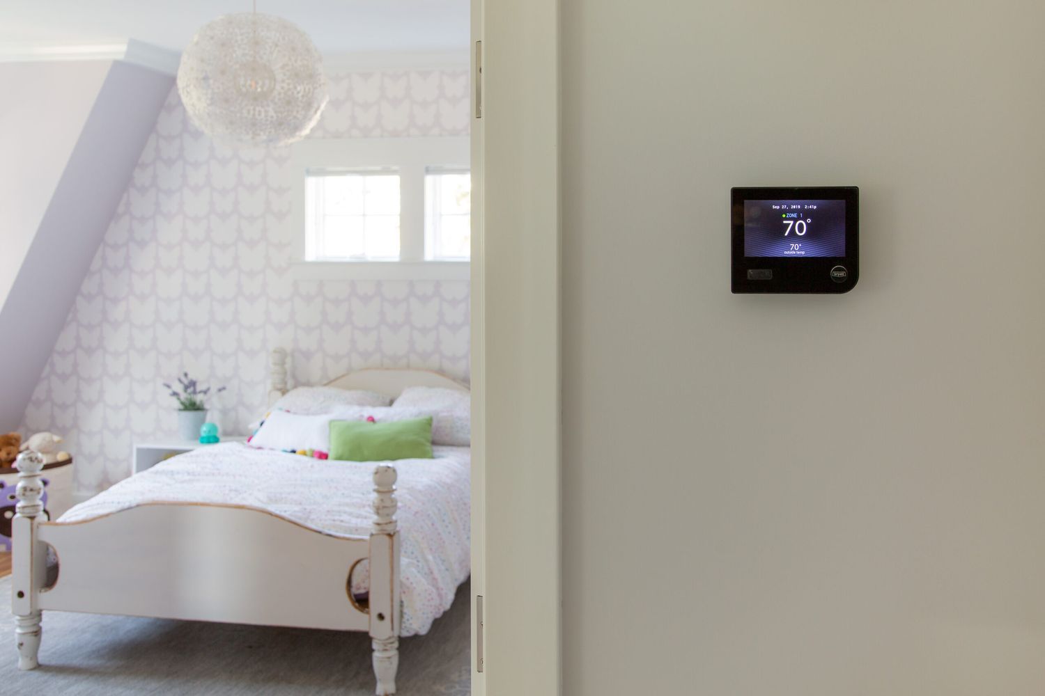 A digital thermostat on the wall of a building.