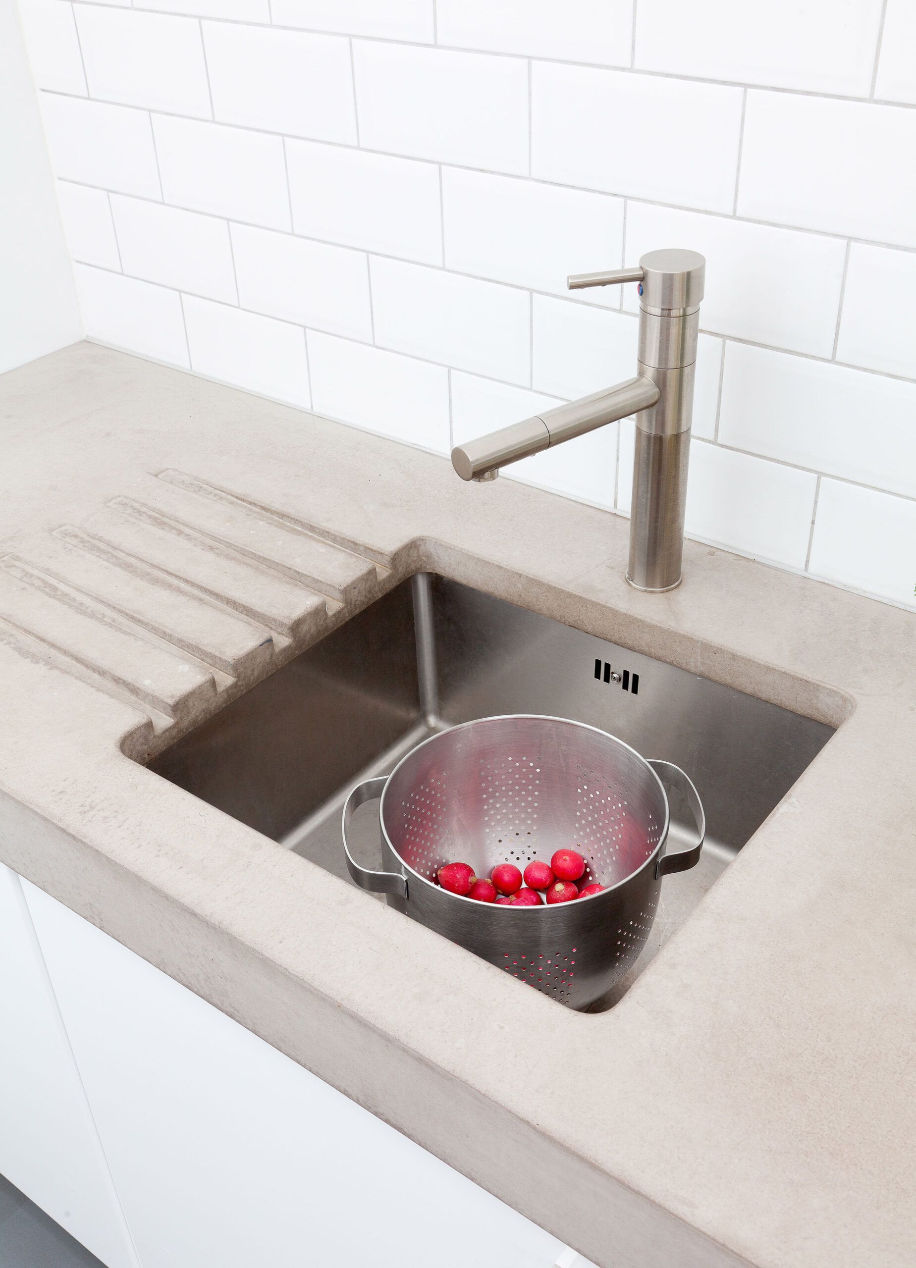 Kitchen sink with concrete countertops with drying groves draining into the sink