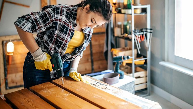 A woman puts together garage shelves.