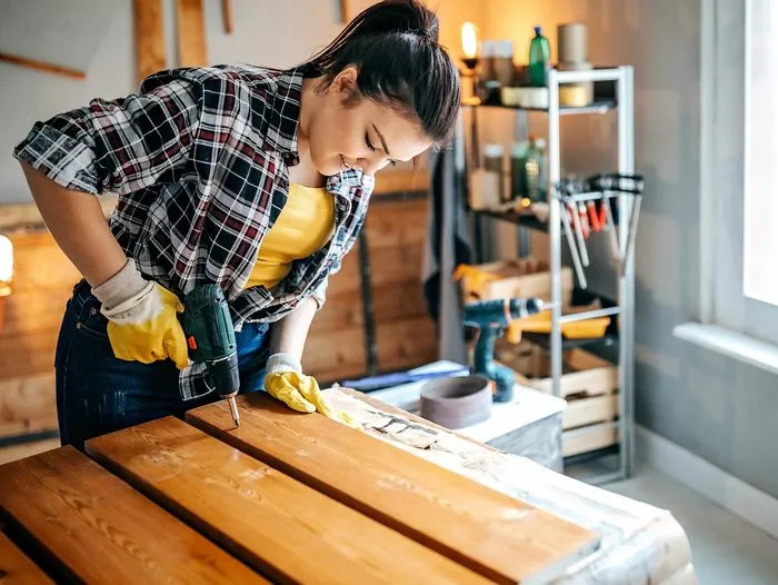 A woman puts together garage shelves.