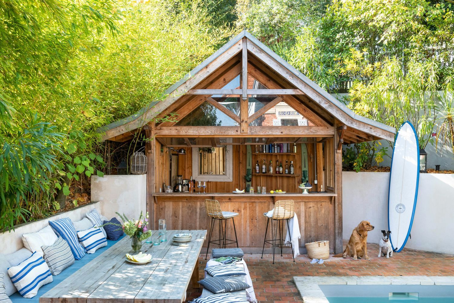 An outdoor bar beside a pool and a surfboard.