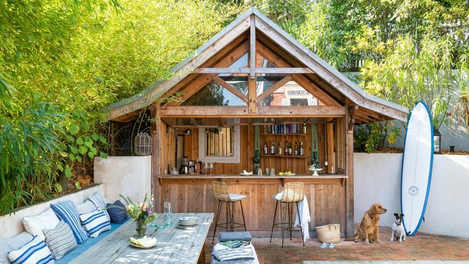 An outdoor bar beside a pool and a surfboard.