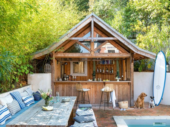 An outdoor bar beside a pool and a surfboard.
