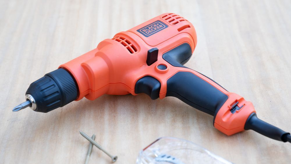 BLACK + DECKER corded drill and screws on a wooden surface. Lead image for Best Drills guide.