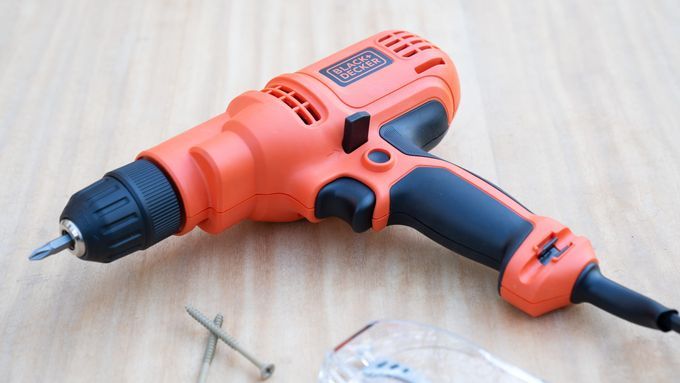 BLACK + DECKER corded drill and screws on a wooden surface. Lead image for Best Drills guide.