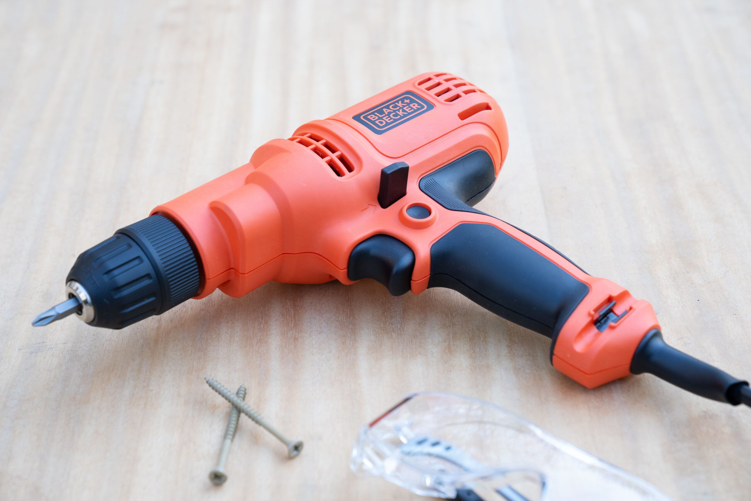 BLACK + DECKER corded drill and screws on a wooden surface. Lead image for Best Drills guide.