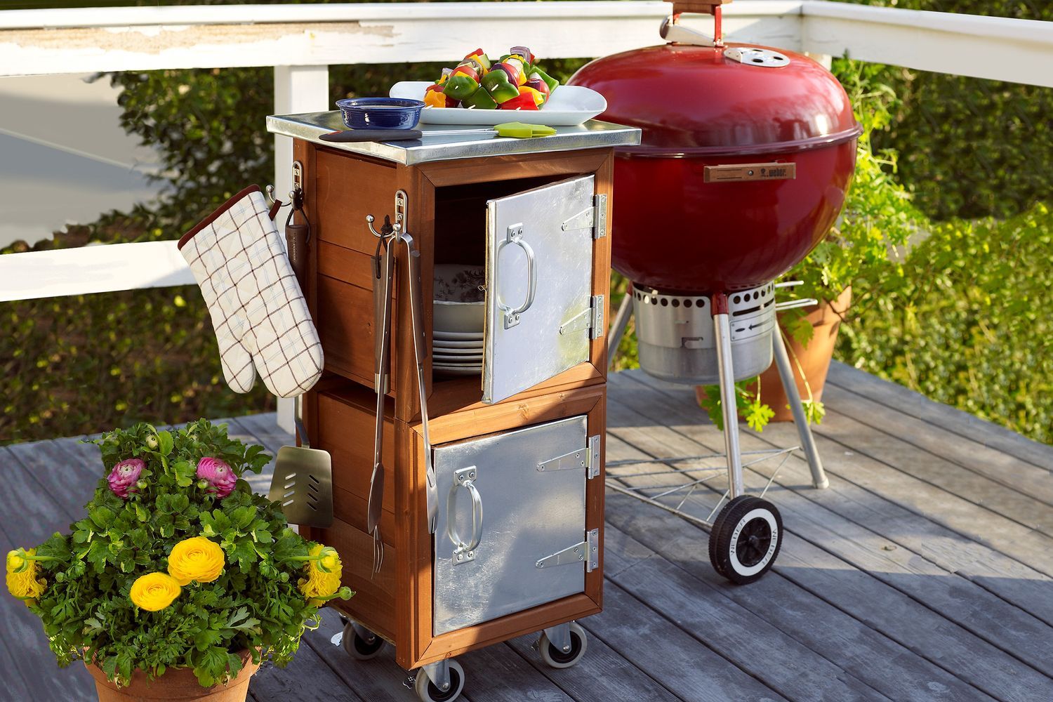 A backyard grilling station beside a plant with yellow flowers