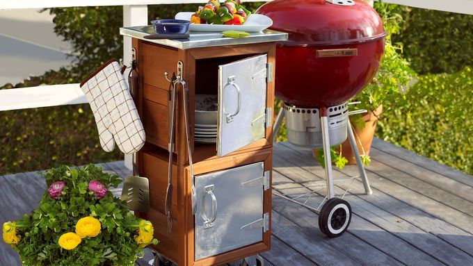 A backyard grilling station beside a plant with yellow flowers