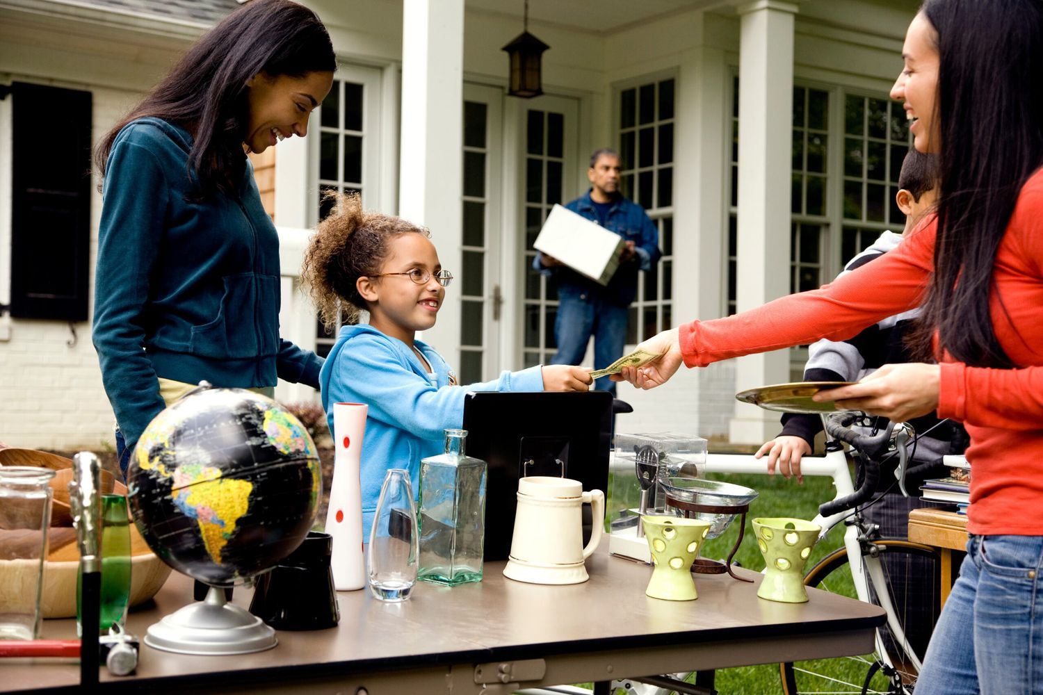 A woman making a purchase at a yard sale.
