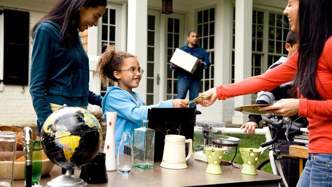 A woman making a purchase at a yard sale.