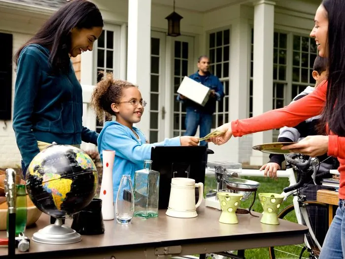A woman making a purchase at a yard sale.