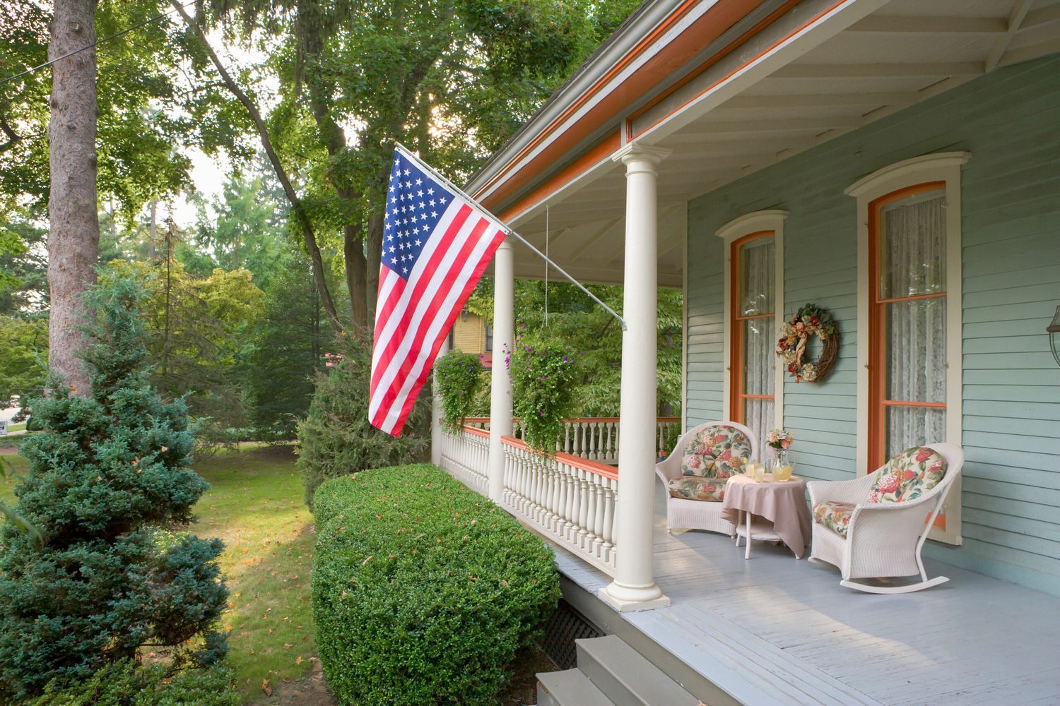 an American flag hanging outside a house in preparation for the fourth of july