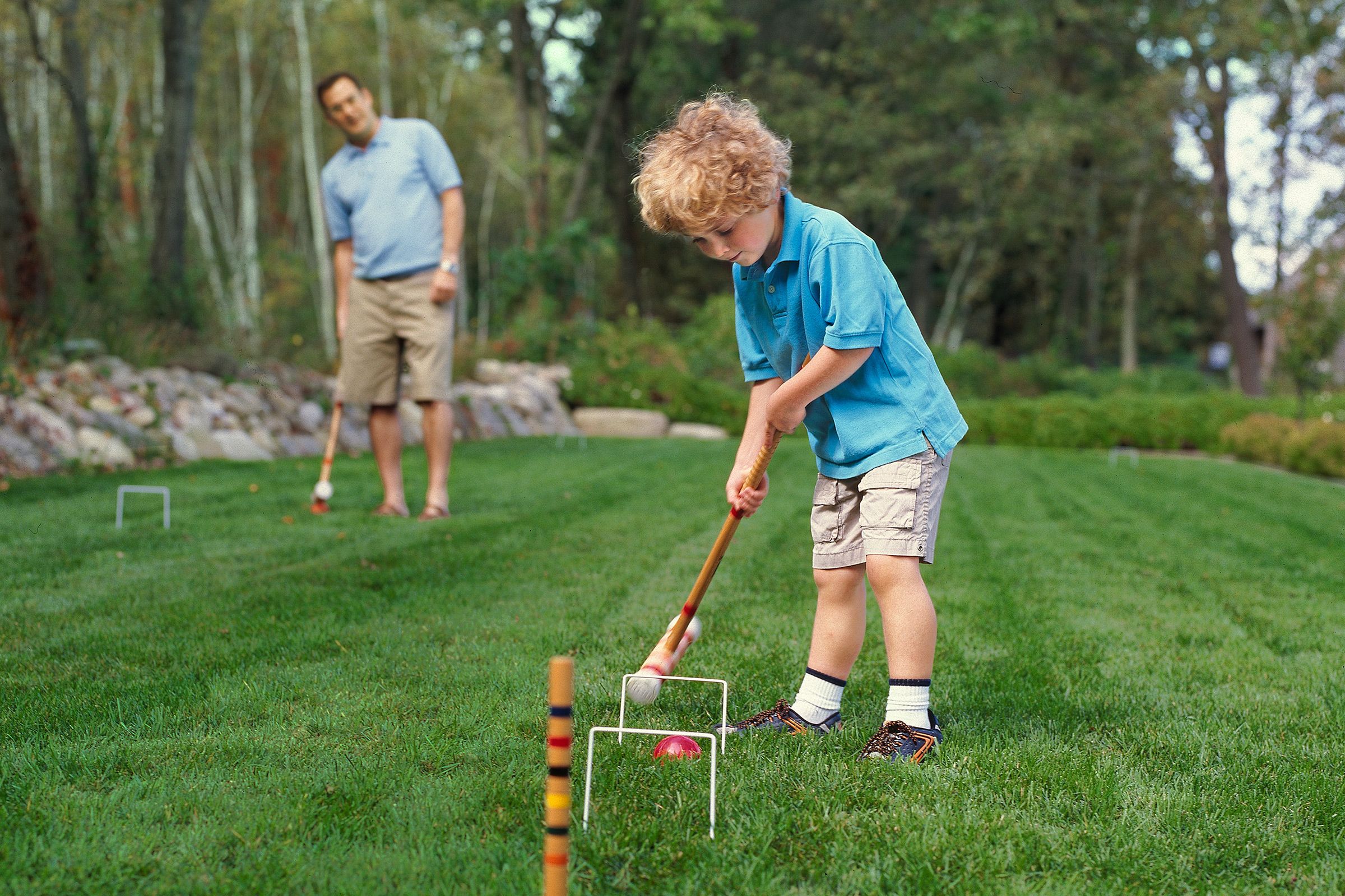 a kid playing croquet