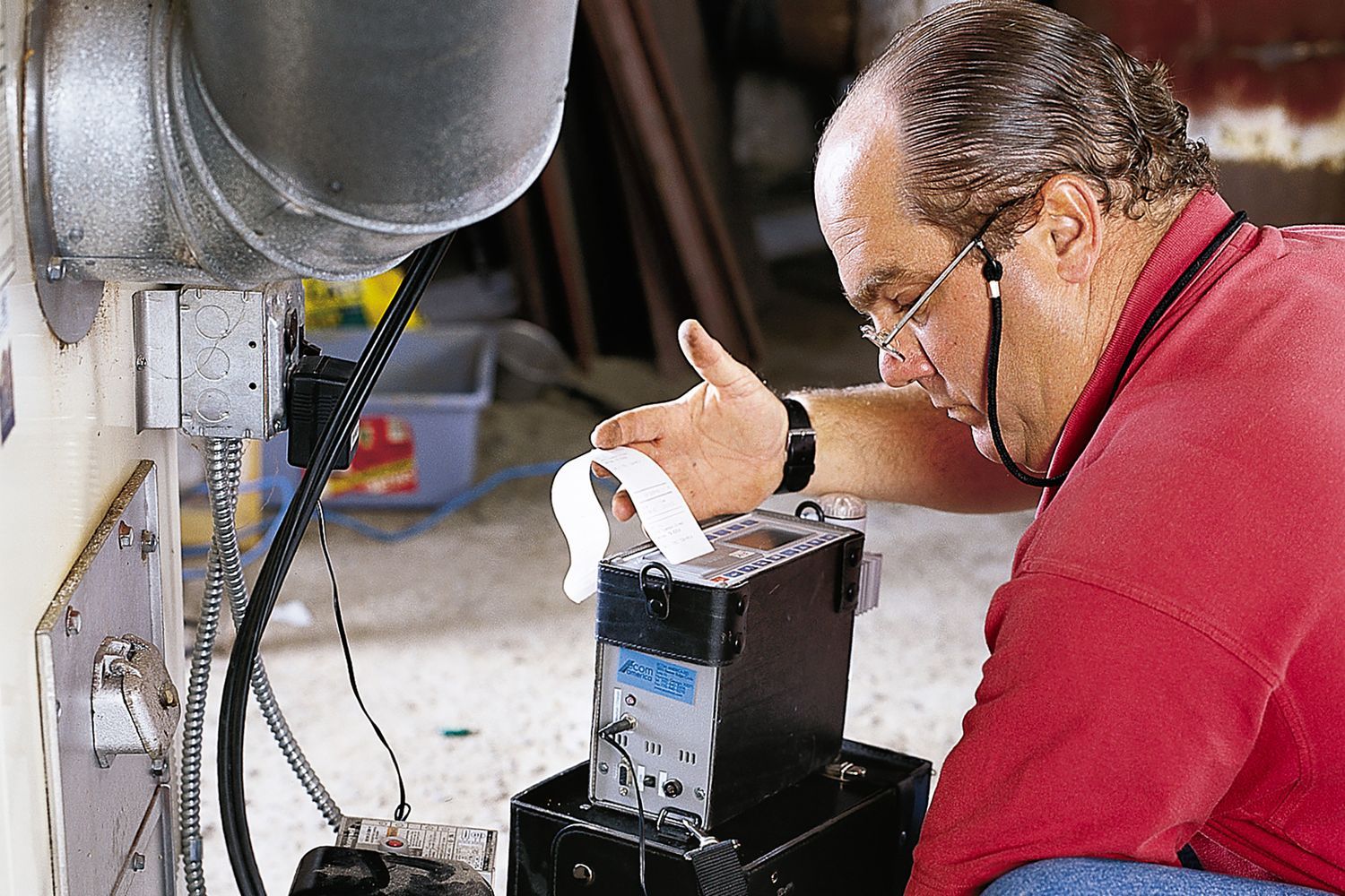 An expert performing annual Fall furnace maintenance