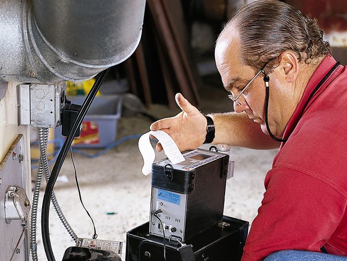 An expert performing annual Fall furnace maintenance