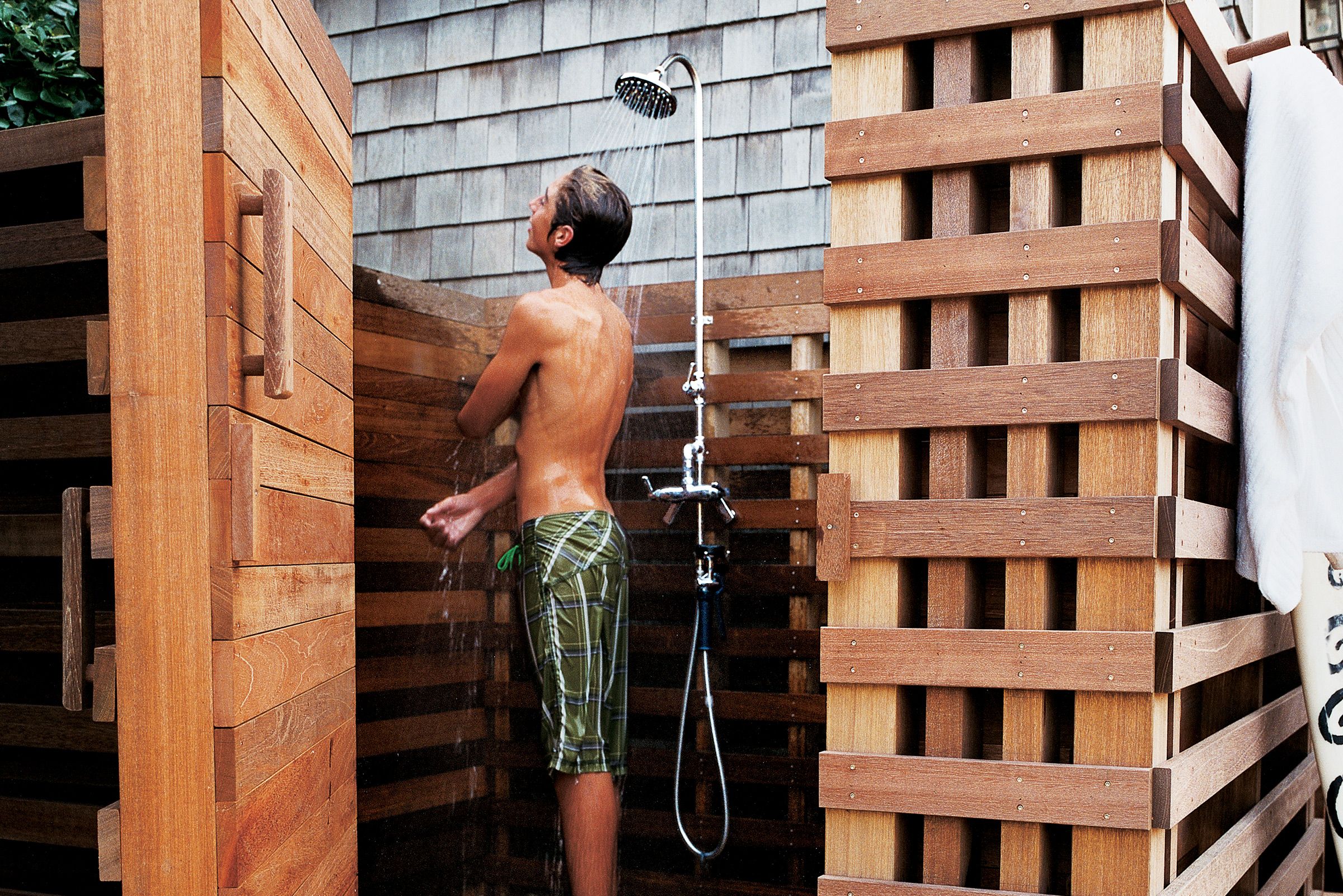 A person bathing using an outdoor shower