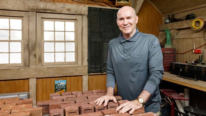 A man standing in front of a table covered in bricks.