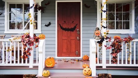 Best Spooky Decor for Halloween - jack-o-lanterns, fall leaves, and other Halloween decorations on front porch of a house