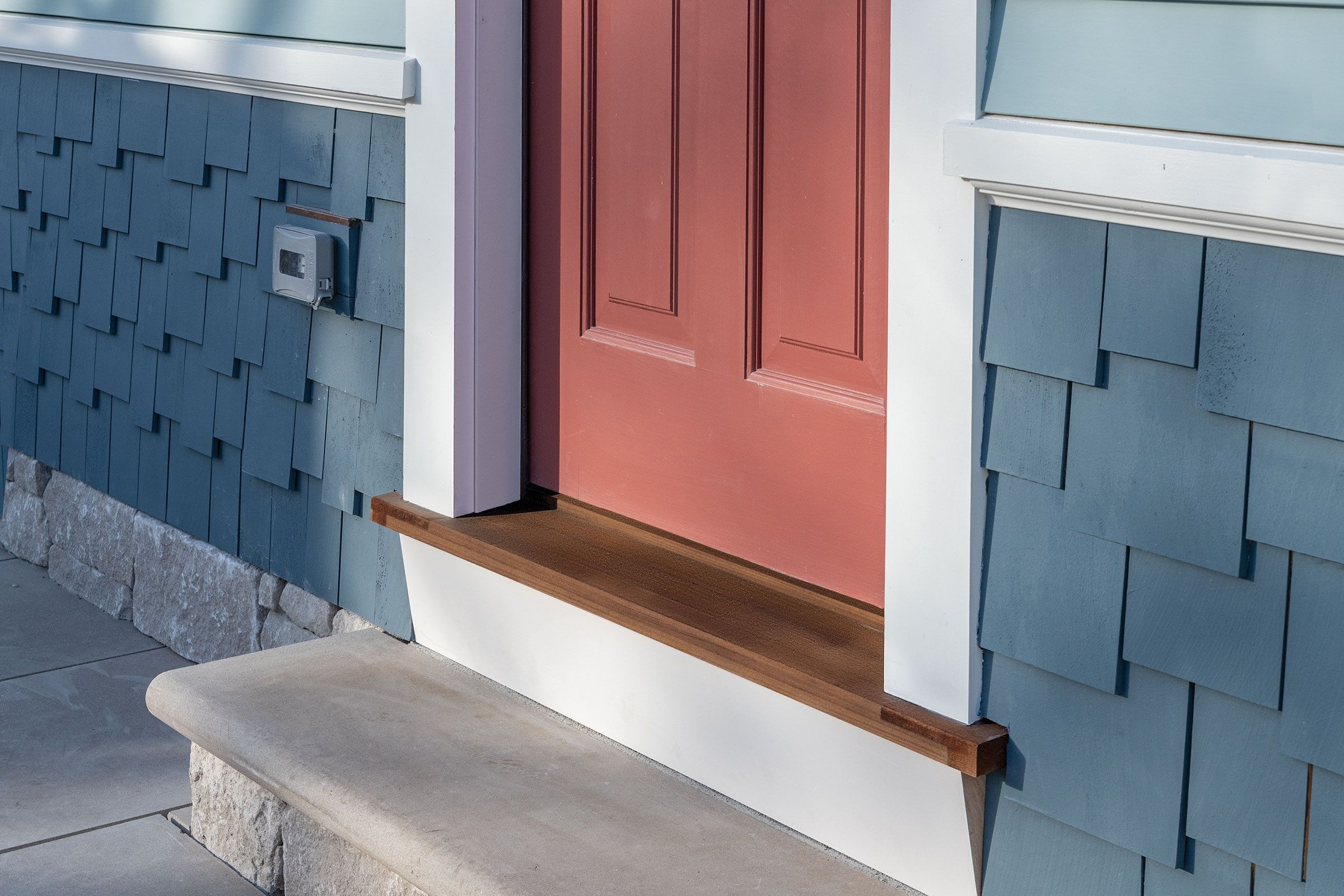 A wood step in front of a home that is prepared for the fall season.