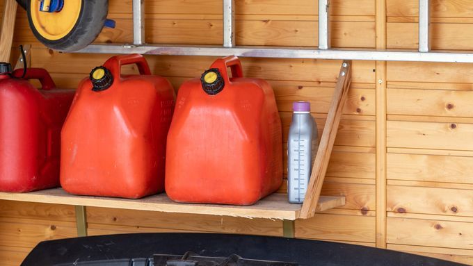 Cans of gasoline in a garage that are expired and need to be disposed of properly