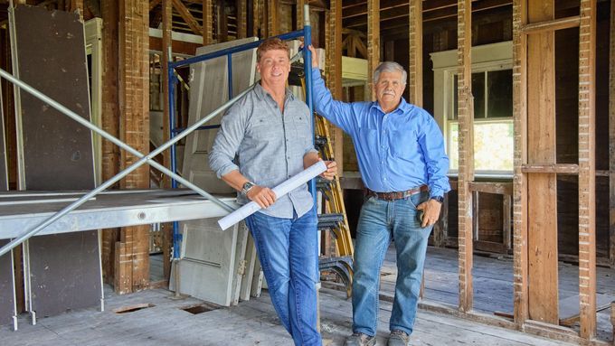 Tom Silva and Kevin O'Connor leaning on scaffolding in an empty house