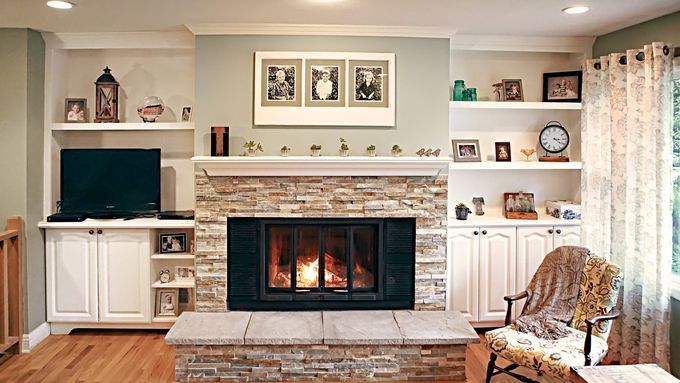 A living room with a cheery fireplace at it's center.