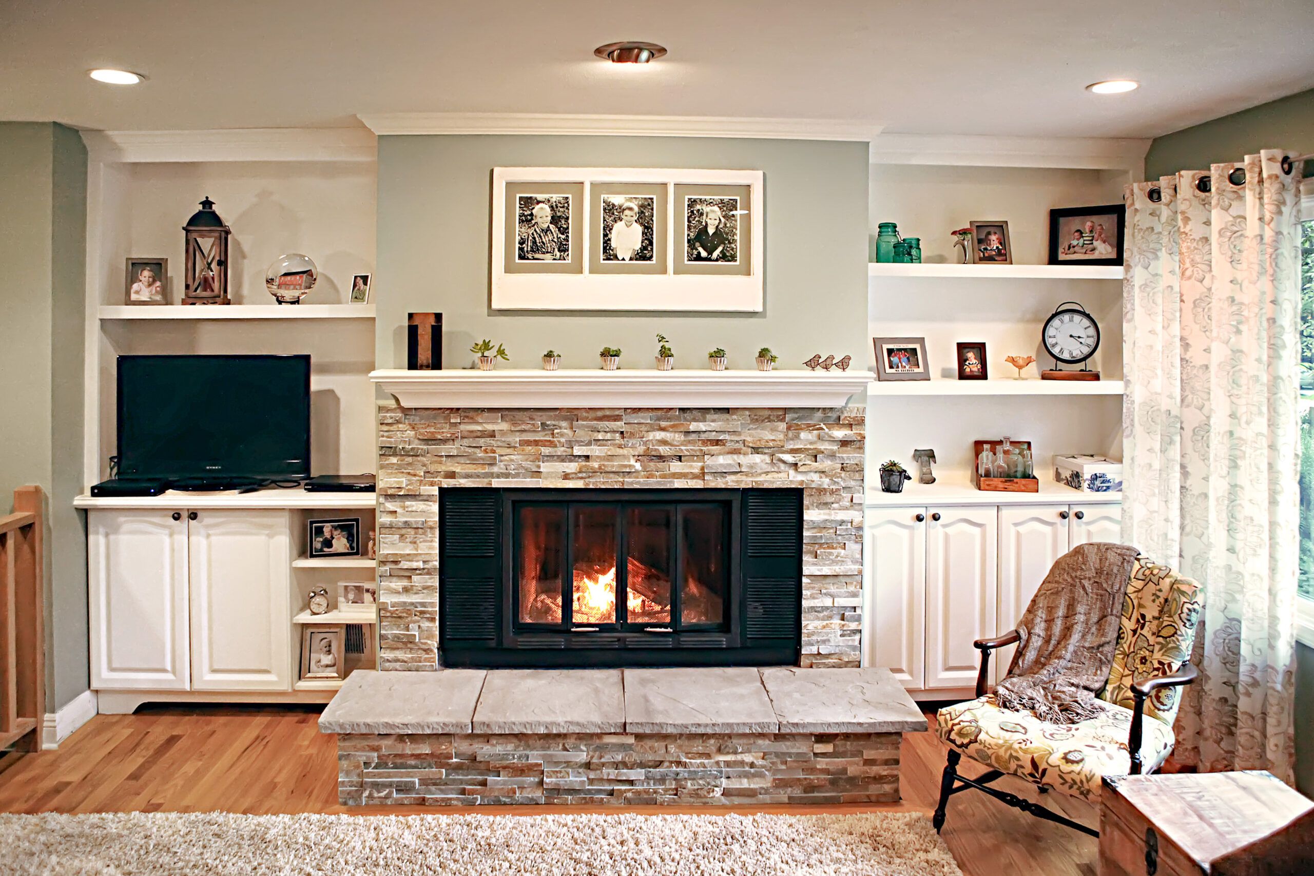 A living room with a cheery fireplace at it's center.