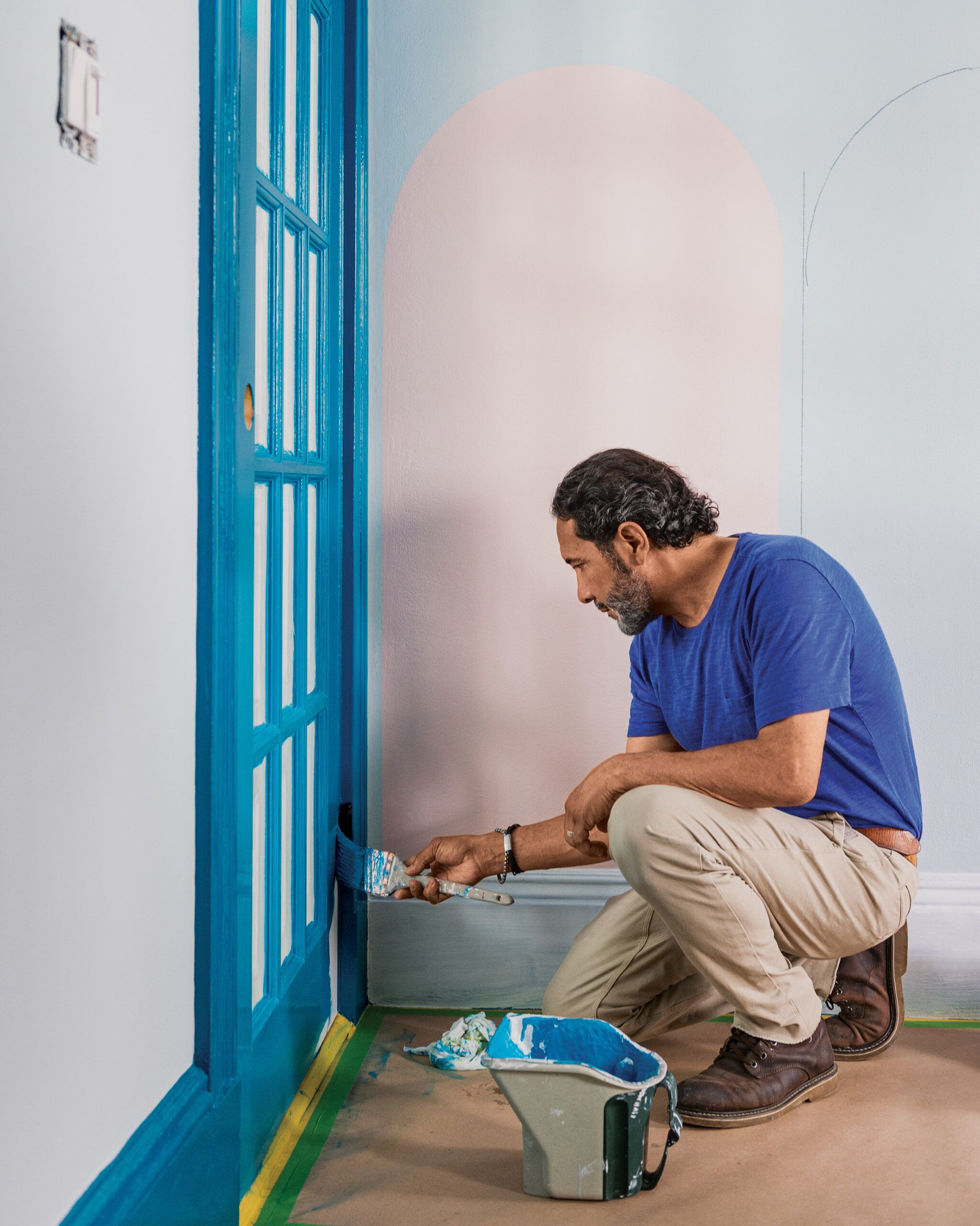 Painting Expert, Mauro Henrique, paints an interior door blue.