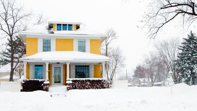 a home that is covered in snow during the winter