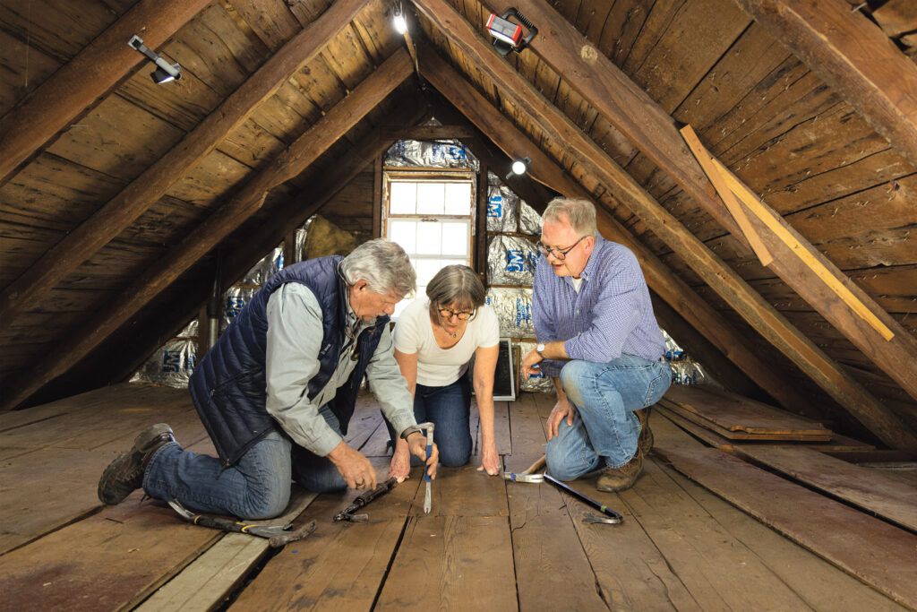 Tom helps the homeowners pull up the wide-plank pine floorboards in the attic of the old ell.