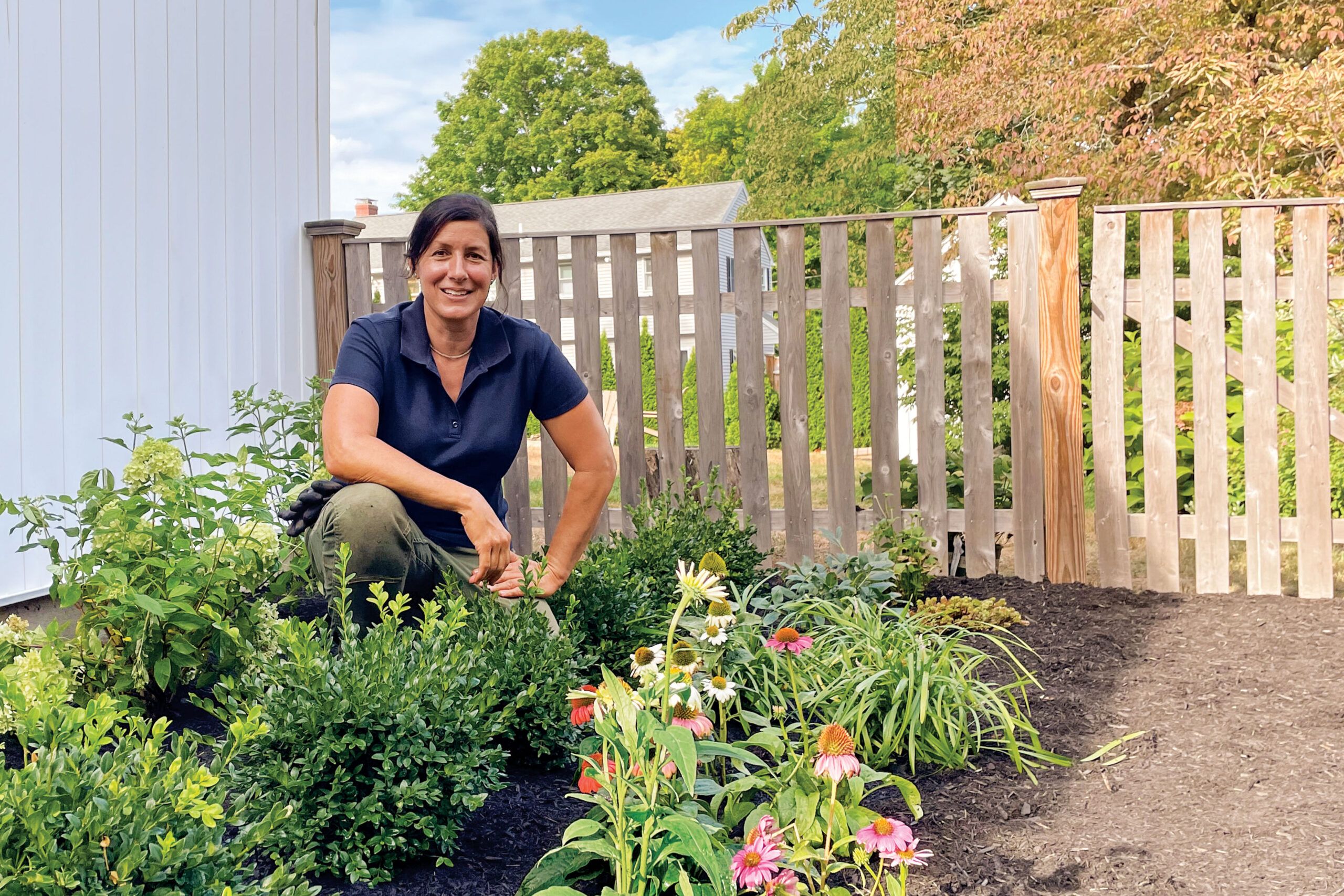 Jenn Nawada in a garden with pollinator plants