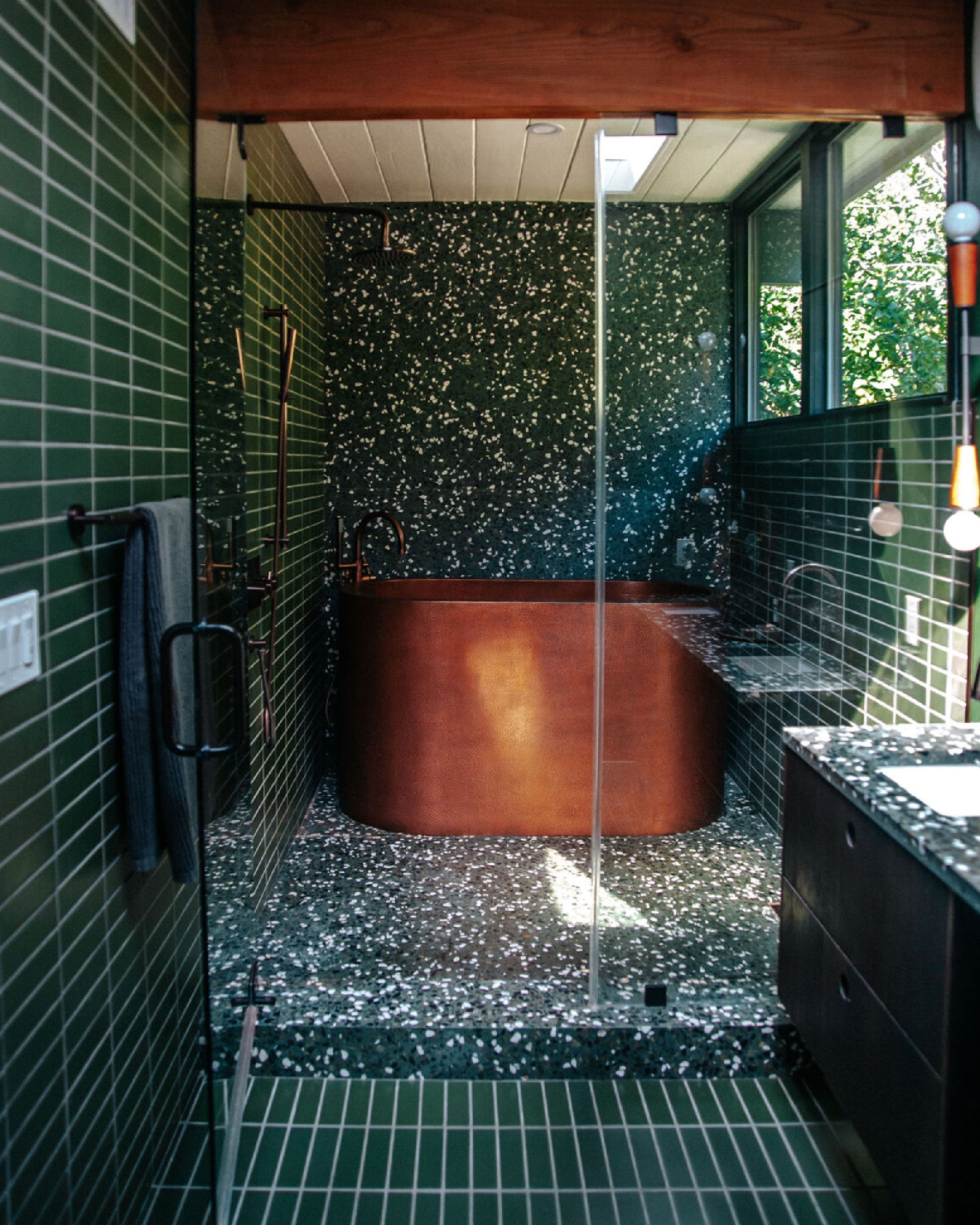 Dark green bathroom with a copper tub