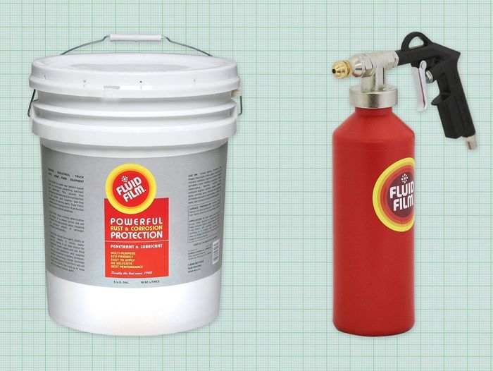 5 gallon tub of Fluid Film and red spray bottle of Fluid film against a green graph paper background. Lead image for best fluid film guide.