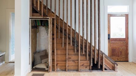 A home that used reclaimed wood as balusters and creates a cozy reading room under the stairs