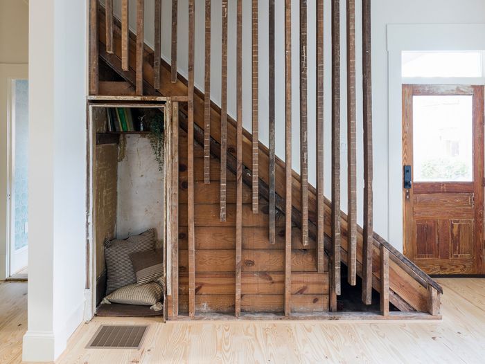 A home that used reclaimed wood as balusters and creates a cozy reading room under the stairs